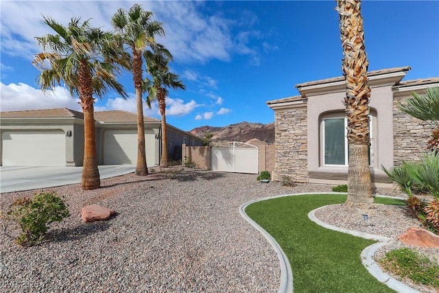 exterior space with concrete driveway, a gate, and an attached garage