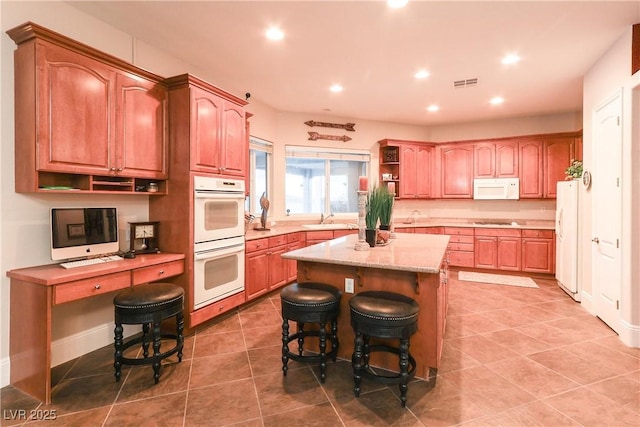 kitchen with visible vents, open shelves, a sink, a center island, and white appliances