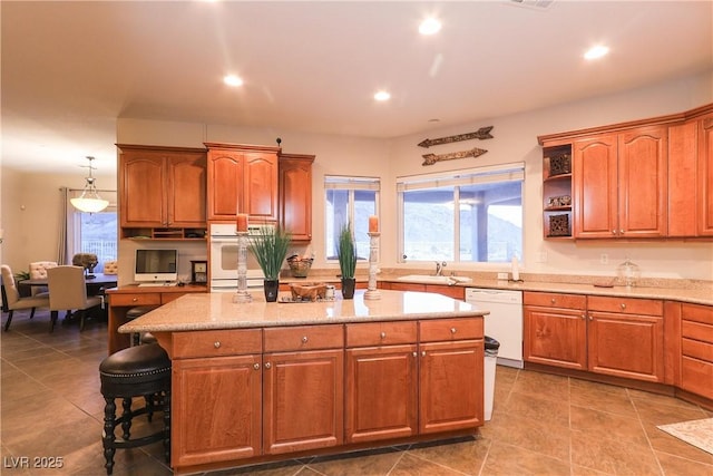 kitchen with recessed lighting, a breakfast bar area, white appliances, and a center island