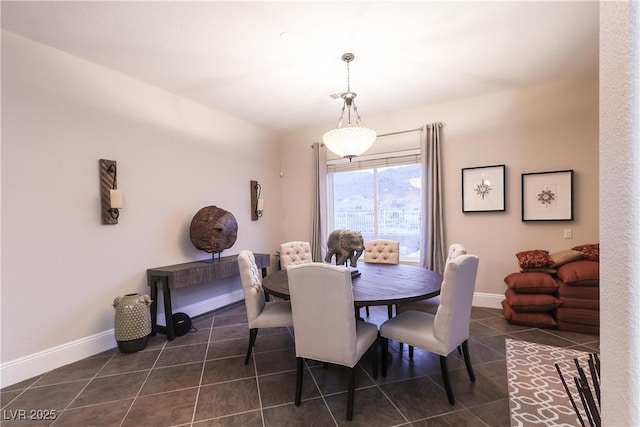 dining area with baseboards and dark tile patterned flooring