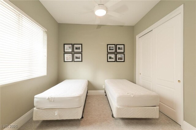 bedroom featuring a ceiling fan, baseboards, a closet, and carpet floors