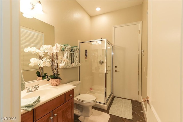 bathroom with vanity, tile patterned floors, toilet, and a stall shower