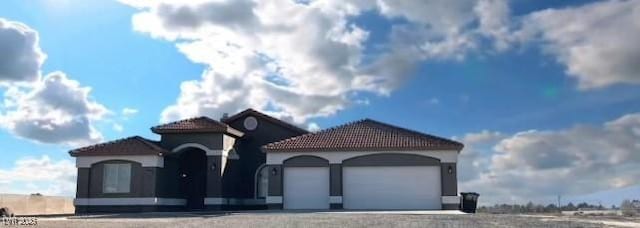 view of front of home with a tiled roof and a garage