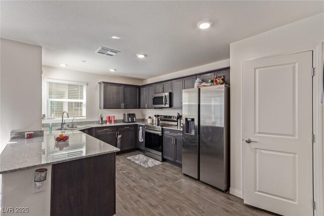 2901 Bahama Yellow Ave, North Las Vegas, NV 89086 - kitchen featuring visible vents, a sink, a peninsula, stainless steel appliances, and light stone counters