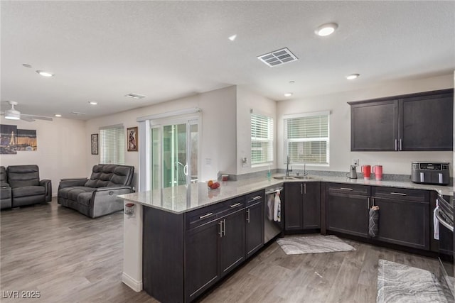 2901 Bahama Yellow Ave, North Las Vegas, NV 89086 - kitchen with visible vents, dishwasher, a sink, a peninsula, and light wood-style flooring