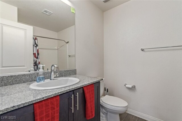 2901 Bahama Yellow Ave, North Las Vegas, NV 89086 - bathroom with visible vents, baseboards, a shower with shower curtain, toilet, and vanity