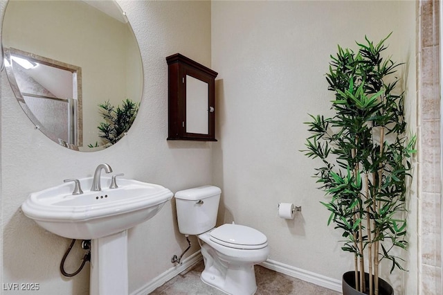 bathroom featuring toilet and baseboards