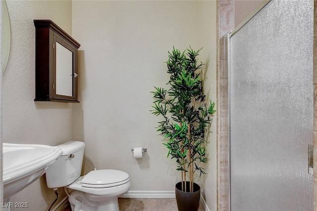 full bath featuring baseboards, a sink, tile patterned flooring, an enclosed shower, and toilet