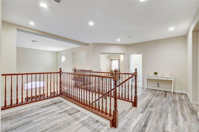 hall with recessed lighting, an upstairs landing, and wood finished floors