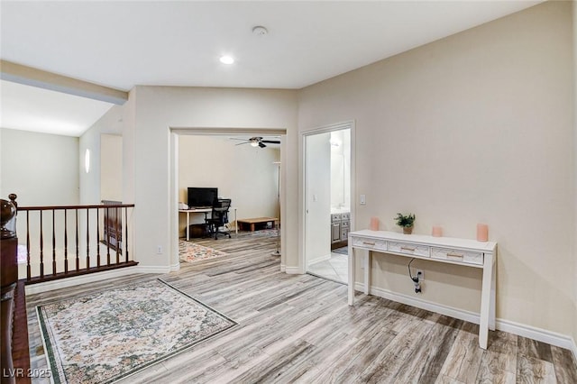 hallway featuring light wood finished floors and baseboards