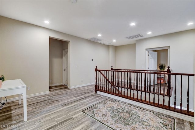 interior space with recessed lighting, an upstairs landing, visible vents, and light wood-type flooring