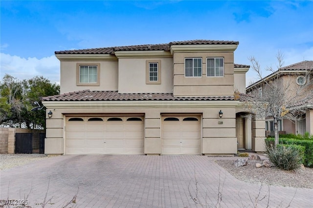 mediterranean / spanish house featuring decorative driveway, an attached garage, and stucco siding