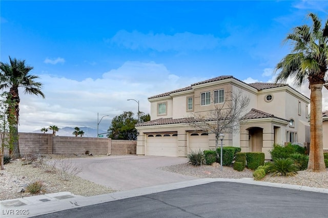 mediterranean / spanish house featuring fence, stucco siding, concrete driveway, a garage, and a tile roof