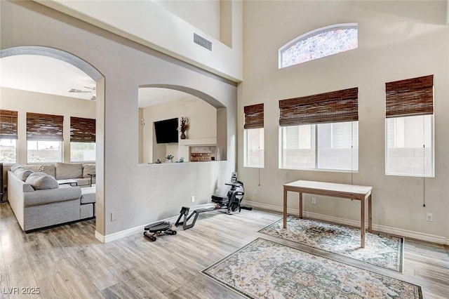 entrance foyer with a high ceiling, wood finished floors, visible vents, and baseboards