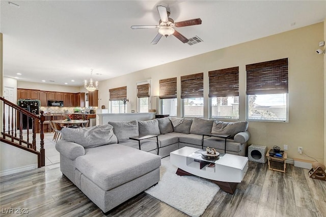 living area with a wealth of natural light, visible vents, and wood finished floors