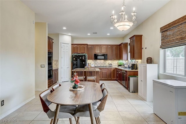 kitchen with light tile patterned floors, a kitchen island, backsplash, and black appliances