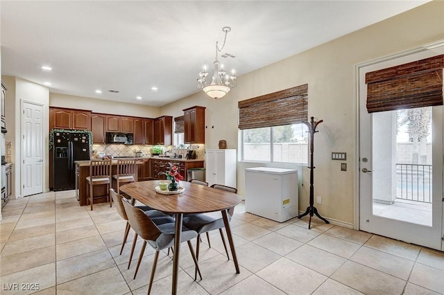 dining area with light tile patterned floors, a notable chandelier, and recessed lighting