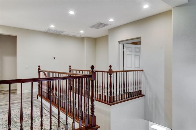 corridor with an upstairs landing, visible vents, recessed lighting, and baseboards