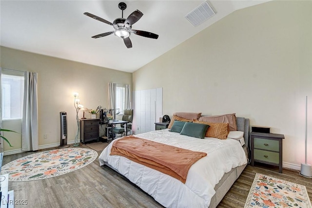 bedroom with visible vents, wood finished floors, and vaulted ceiling