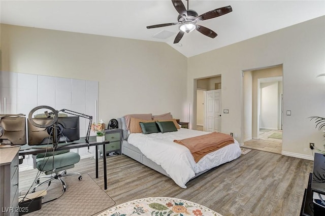 bedroom with a ceiling fan, vaulted ceiling, light wood-style floors, and baseboards