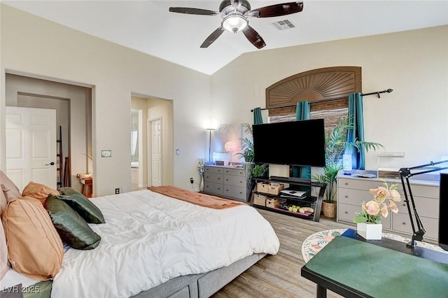 bedroom with ceiling fan, visible vents, wood finished floors, and vaulted ceiling