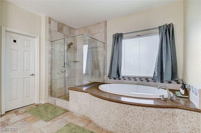 bathroom featuring a bath, a stall shower, and stone tile flooring