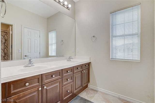 bathroom featuring a sink, baseboards, double vanity, and tile patterned floors