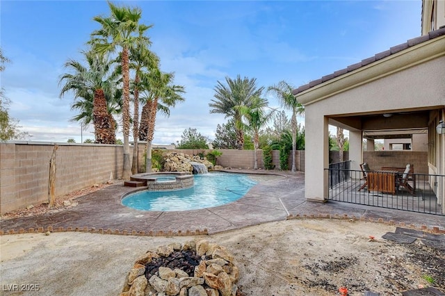 view of pool with a pool with connected hot tub, a fenced backyard, and a patio area