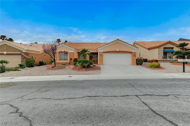 view of front of house featuring a tile roof, an attached garage, concrete driveway, and stucco siding