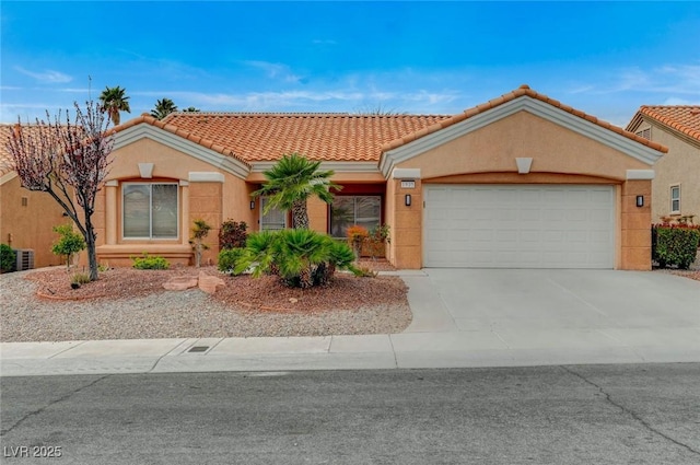 view of front of property featuring a tile roof, a garage, driveway, and stucco siding