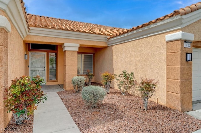 entrance to property featuring stucco siding and a tiled roof