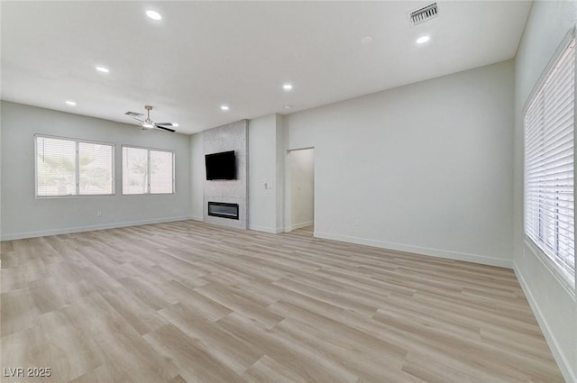 unfurnished living room with visible vents, a large fireplace, baseboards, recessed lighting, and light wood-style flooring