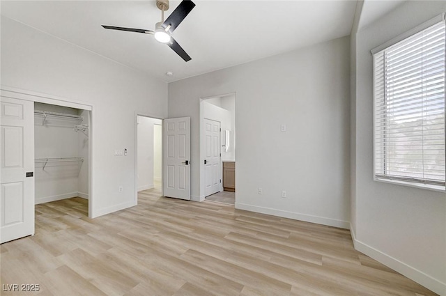 unfurnished bedroom featuring multiple windows, baseboards, and light wood finished floors