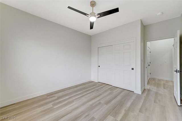 unfurnished bedroom with ceiling fan, a closet, baseboards, and light wood-style flooring