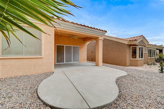 back of property featuring a patio area, stucco siding, a tiled roof, and a ceiling fan