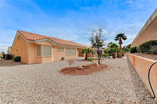 exterior space featuring a tiled roof, central AC, and stucco siding