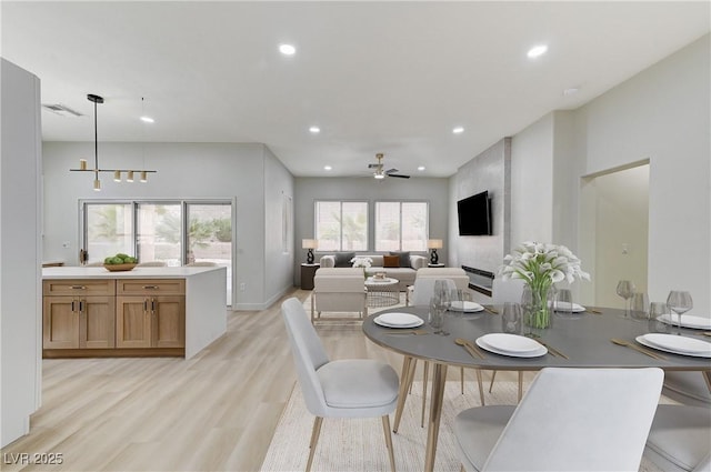 dining space with light wood-type flooring, visible vents, a ceiling fan, recessed lighting, and baseboards