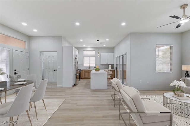 living room with light wood-style flooring, recessed lighting, baseboards, and ceiling fan