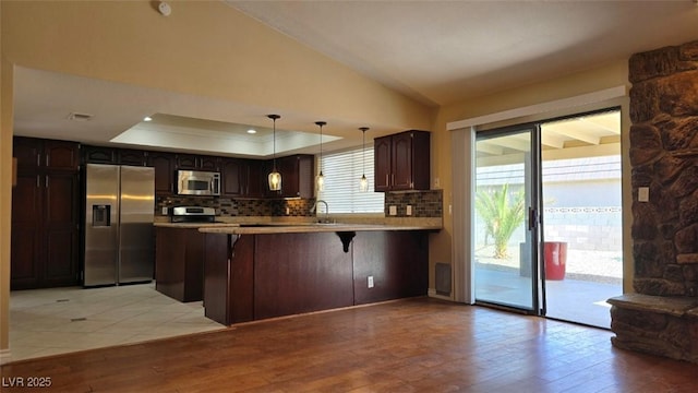 kitchen with tasteful backsplash, visible vents, appliances with stainless steel finishes, a raised ceiling, and a sink