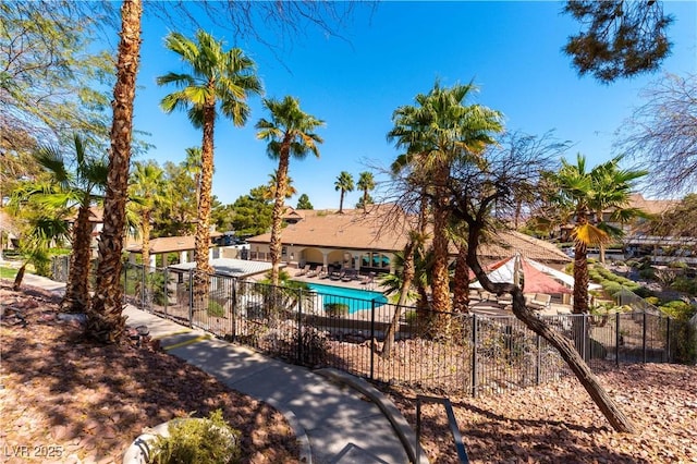 community pool with a patio area and fence