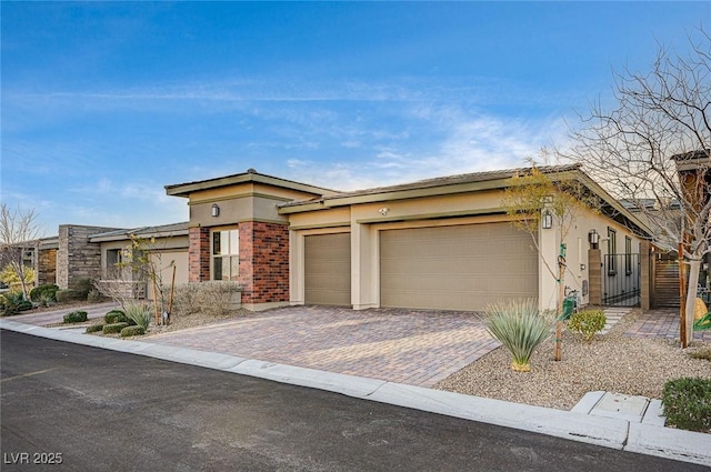 view of front of home with brick siding, stucco siding, an attached garage, and decorative driveway