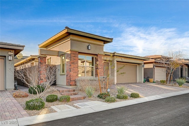 view of front facade with a garage, driveway, and stucco siding