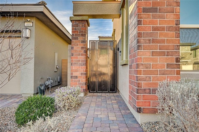 doorway to property featuring brick siding and stucco siding