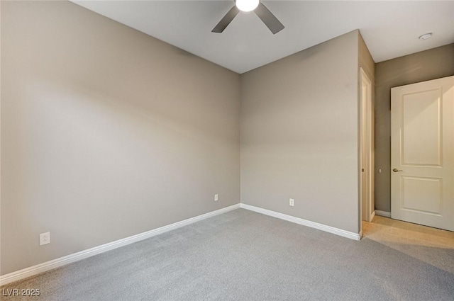 carpeted spare room with baseboards and ceiling fan