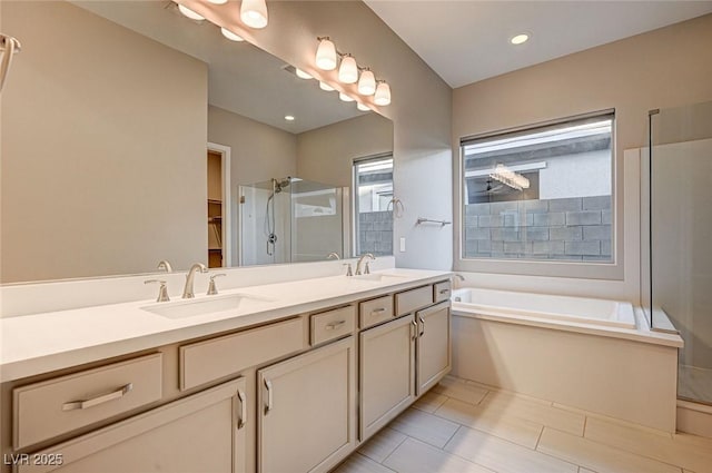 bathroom with double vanity, a bath, a stall shower, and a sink