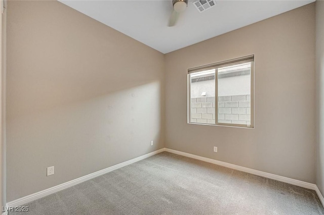 carpeted empty room with visible vents, baseboards, and a ceiling fan