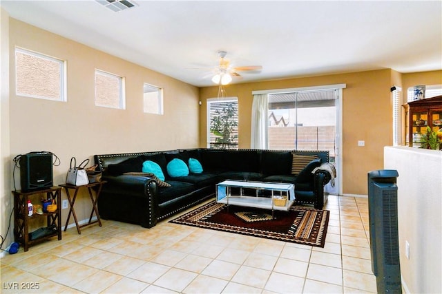 living room with light tile patterned floors, visible vents, baseboards, and a ceiling fan