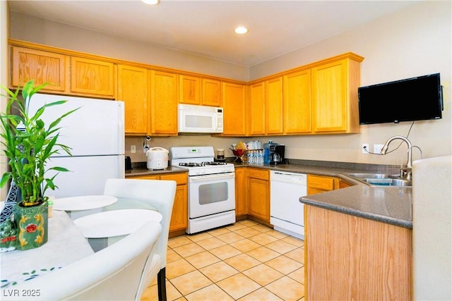 kitchen featuring white appliances, light tile patterned flooring, recessed lighting, a sink, and dark countertops