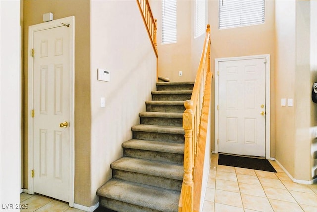 stairs with tile patterned floors and baseboards