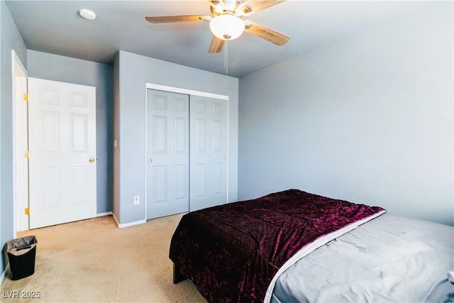 bedroom with a ceiling fan, a closet, and light carpet